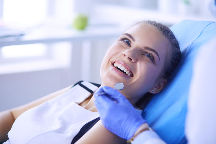 Young Female Patient With Pretty Smile Examining Dental Inspection At Dentist Office.